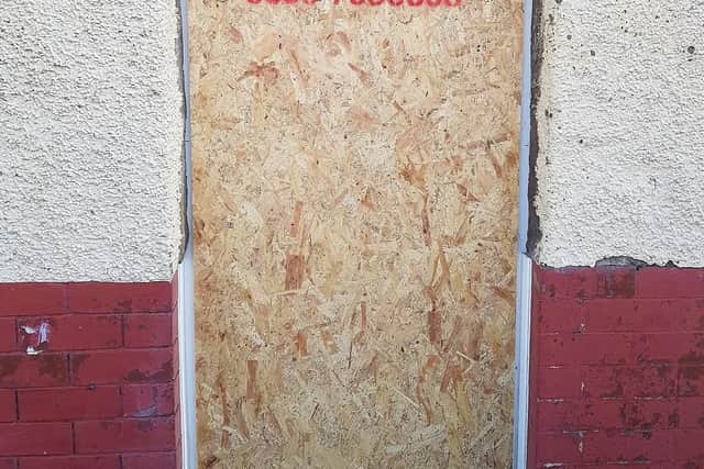 The boarded-up door after the police raid on Basil Street