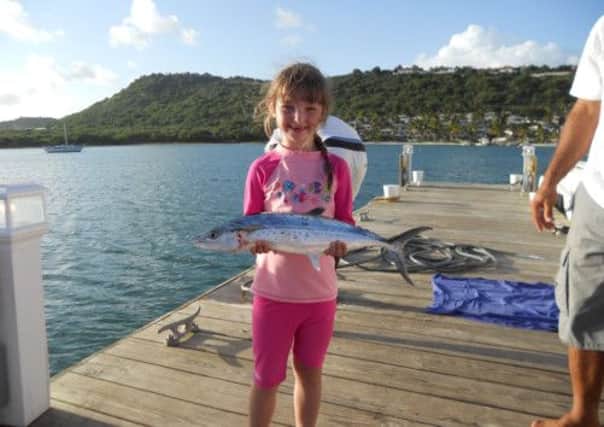 DADDY-DAUGHTER DAY: Isla holding a fish after a snorkelling trip near the Atlantic Ocean, Antigua