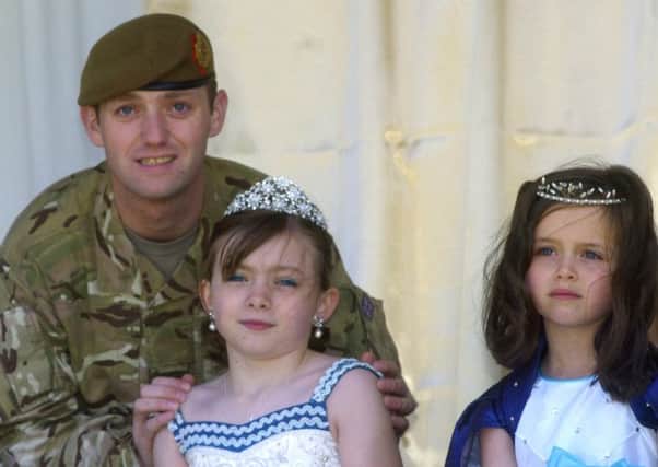 Corporal Wayne Stavert from the Duke of Lancaster Regiment crowns his niece Louise Ashton, nine, as Catterall Gala Queen for 2013 with Rose Bud, Georgia Wilkes, six.