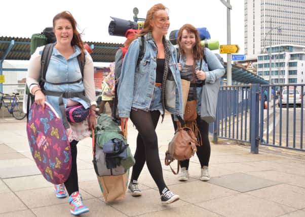 Clare Thornhill, 26, (left) Charlotte Gillett, 22, and Lucy Judge, 23, (right), all from Preston, Lancashire, arrive to catch the catamaran passenger ferry at Portsmouth, Hampshire, to cross the Solent to get to the Isle of Wight Festival which is being headlined by Bon Jovi, The Killers and The Stone Roses.
