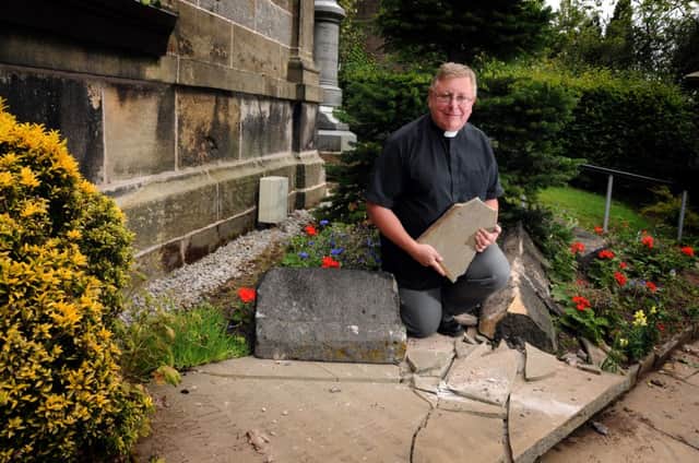 The Rev Brian Whitley surveys damage to gravestones at St Annes Church, Woodplumpton