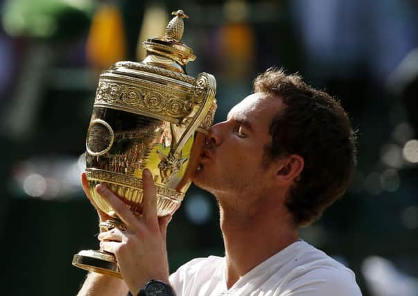 Great Britain's Andy Murray celebrates with the trophy after defeating Serbia's Novak Djokovic in the Men's Final during day thirteen of the Wimbledon Championships at The All England Lawn Tennis and Croquet Club, Wimbledon. PRESS ASSOCIATION Photo. Picture date: Sunday July 7, 2013. See PA story TENNIS Wimbledon. Photo credit should read: Jonathan Brady/PA Wire. 
RESTRICTIONS: Editorial use only. No commercial use. No video emulation. No use with any unofficial third party logos.