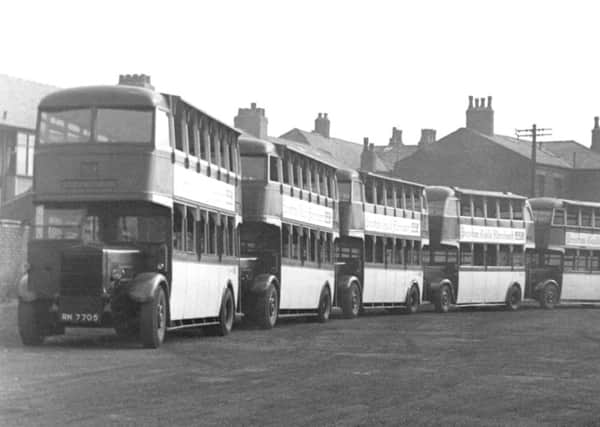 Line-up: Row of ancient double-decker buses, below, Mike Rhodes of Ingol with his Preston Bus book
