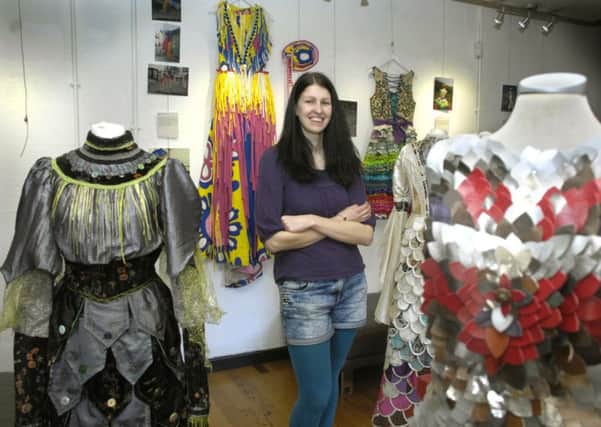 Katie Duxbury with some of the costumes featured in the Piece By Piece exhibition at The Dukes gallery