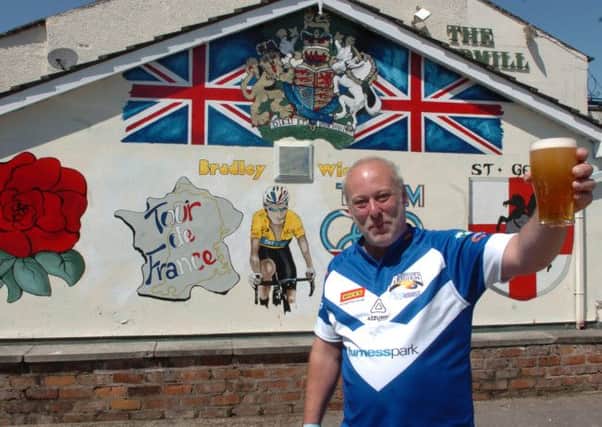 Barry Woods raises a glass to Tour de France winner Bradley Wiggins after painting this mural on the wall of the now-closed Eccleston pub The Windmill