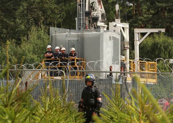 Police officer standing at the perimeter fence of the Cuadrilla exploratory drilling site in Balcombe, West Sussex