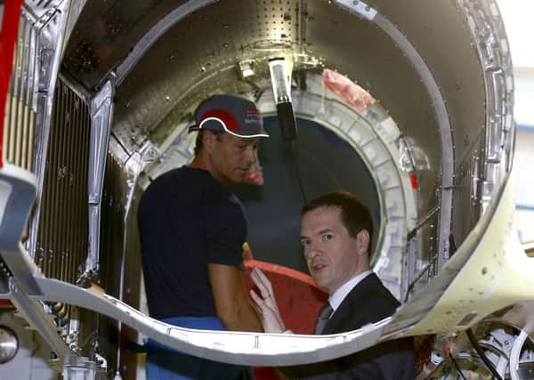Chancellor of the Exchequer George Osborne (right) looks inside the engine casing of a Eurofighter Typhoon fighter jet during his visit to BAE Systems in Warton, Lancashire