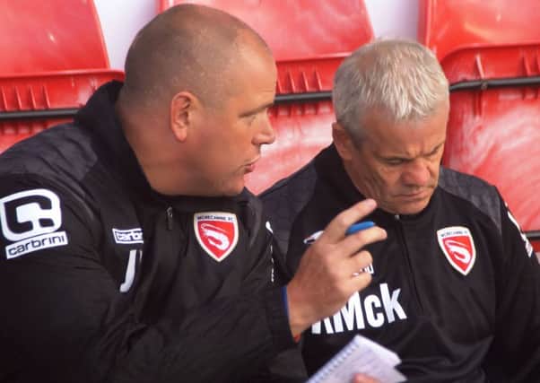 Morecambe boss Jim Bentley and his assistant Ken McKenna talk tactics during the game against Bolton.