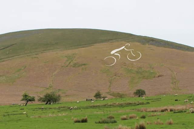A giant cyclist constructed from 1,500 metres of horticultural fleece on Pendle Hill.