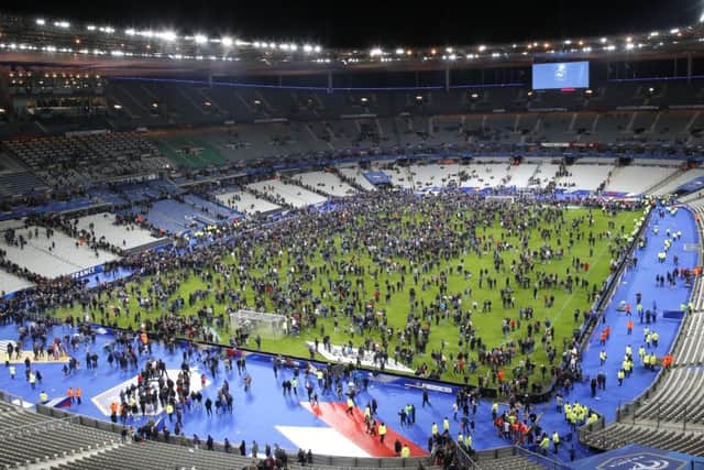 Spectators invade the pitch of the Stade de France stadium after the international friendly soccer France against Germany, Friday, Nov. 13, 2015 in Saint Denis, outside Paris. At least 35 people were killed in shootings and explosions around Paris, many of them in a popular theater where patrons were taken hostage, police and medical officials said Friday.  Two explosions were heard outside the Stade de France stadium.