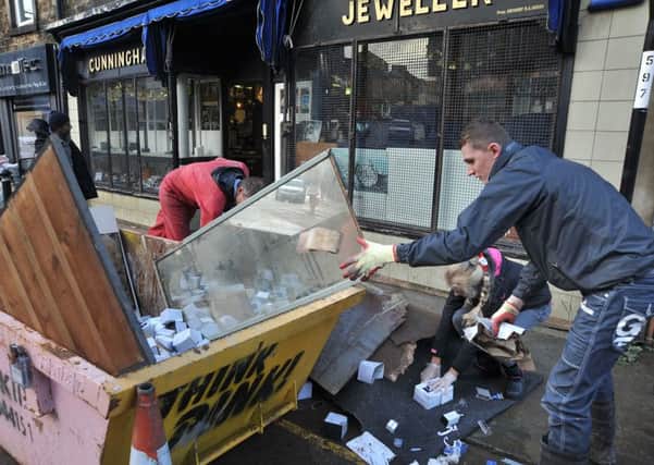 Aftermath of the unprecedented flooding over the weekend in Lancaster.
 Members of the Gregg family fill a skip with the ruined contents of their business, Cunningham Jewellers on Chapel Street.  PIC BY ROB LOCK