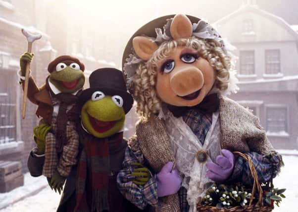 Robin the frog as Tiny Tim (voiced by Jerry Nelson), Kermit the frog as Bob Cratchit (voiced by Steve Whitmire) and Miss Piggy as Emily Cratchit (voiced by Frank Oz) in The Muppet Christmas Carol