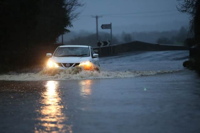 An car takes the risk of driving through flood water. The village of Ribchester on the River Ribble, Lancashire has burst its banks in the early hours of this morning Saturday 26 December. A Severe flood warning has been issued with a danger to life. Heavy rain fell over Christmas night and forecasters have warned it will continue in Lancashire for most of the day. Rivers in the are are expected to peak around mid-day.