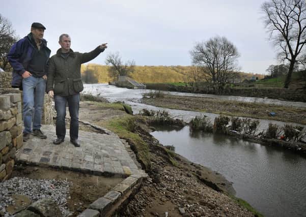Allan Elliott, of Calder Vale in Whalley, shows MP for Ribble Valley Nigel Evans the spectacular erosion of his garden by the river (the shrubs close to the river mark where lawn used to reach). Pic: Rob Lock.