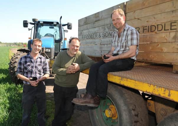 John Fiddler, left, and his father and brother, both called Robert, on the farm where they make Lancashire Crisps.