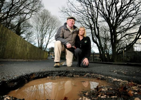 Borough coucillor Eric Bell and Cheeky Monkeys general manager Sharon Reed inspect the severity of potholes on Factory Lane in Whittle-le-Woods