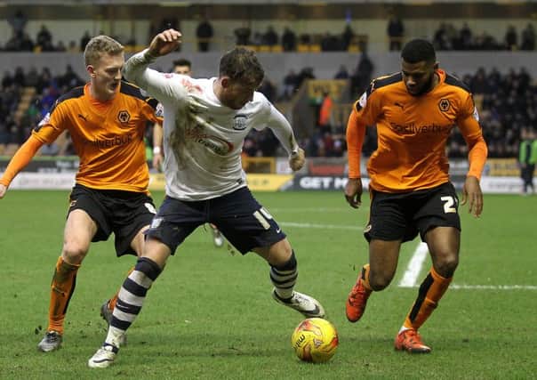 Joe Garner shields the ball from Wolves players George Saville and Ethan Ebanks-Landell at Molineux