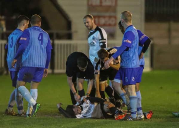 PAIN GAME: Stuart Vasey lies injured after a red-card challenge in the game against New Mills in midweek (photo by Paul Vause)