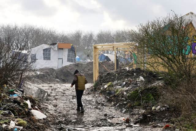 A man walks through the Jungle migrant camp in Calais, France