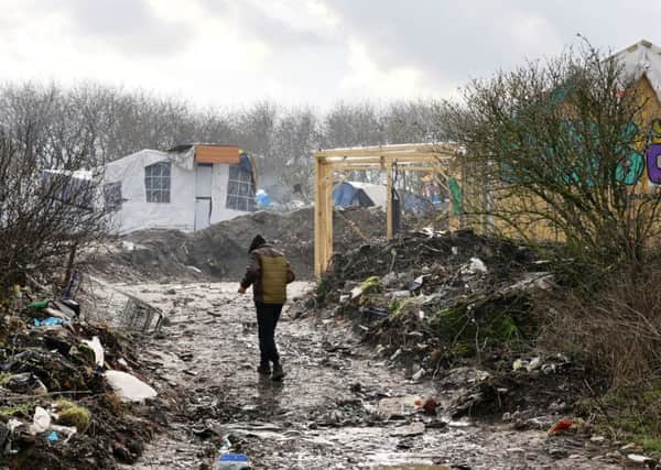 A man walks through the Jungle migrant camp in Calais, France