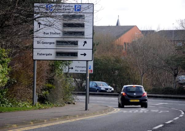 Road signs on Ringway in Preston which have been adjusted to allow cyclists to pass underneath on the shared-space pavement