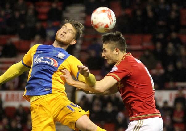 Joe Garner jumps for the ball at the City Ground