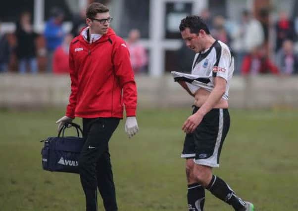 Brig defender Glenn Steel trudges off to recieve treatment after allegedly being elbowed in the face