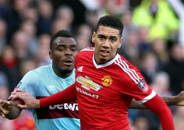 Chris Smalling and Emmanuel Emenike (left) of West Ham during the FA Cup quarter-final match at Old Trafford