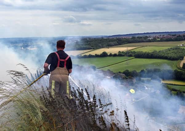 Firefighters tackle one of a series of grass fires  in Overthorpe, Dewsbury. Smoke from the fires, thought to have started deliberately, engulfed nearby homes.