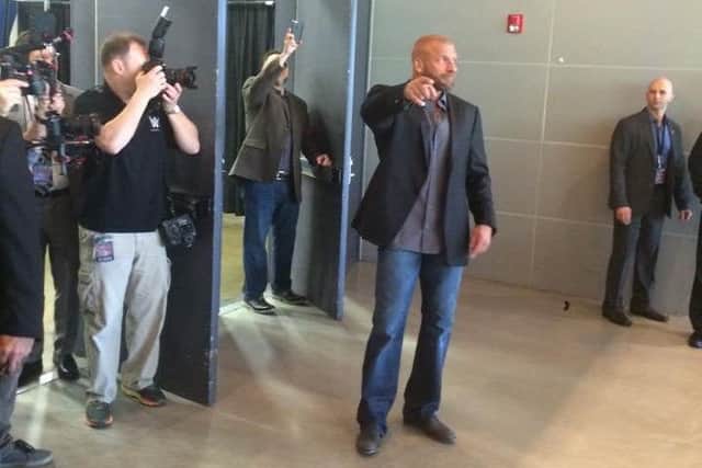 WWE World Champion Triple H comes out to greet queuing fans outside WWE Axxess on Thursday.