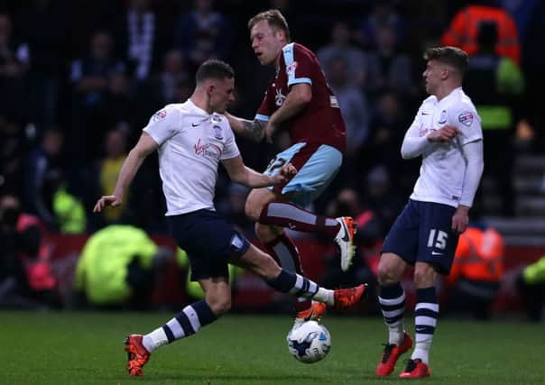 Alan Browne (left) and Calum Woods (right) battles with Burnley's Scott Arfield at Deepdale