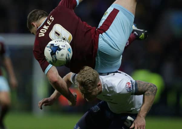 Sam Vokes climbs over the back of Preston's Tom Clarke in the Deepdale derby against Burnley