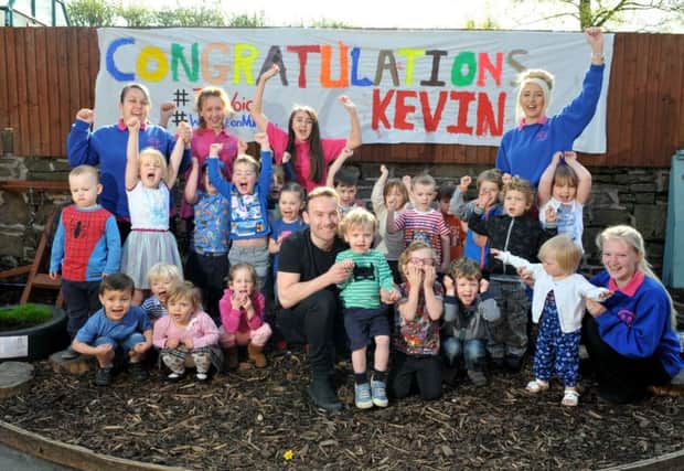 Kevin Simm at  Wheelton Nursery where children  had made a banner congratulating him for The Voice and, below, with his children Charlie and Oliver