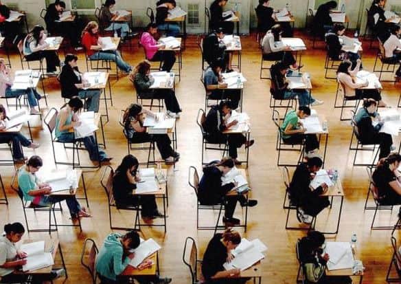 Students sitting exams. Turning schools into academies will feature in the Queen's Speech, but blanket conversion plans have been dropped. Rui Vieira/PA Wire