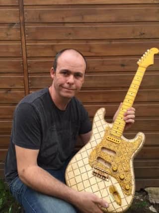Ex-serviceman Dean Fraser, aged 37, from Chorley, has made an electric guitar entirely out of matchsticks. Credit: Dean Fraser