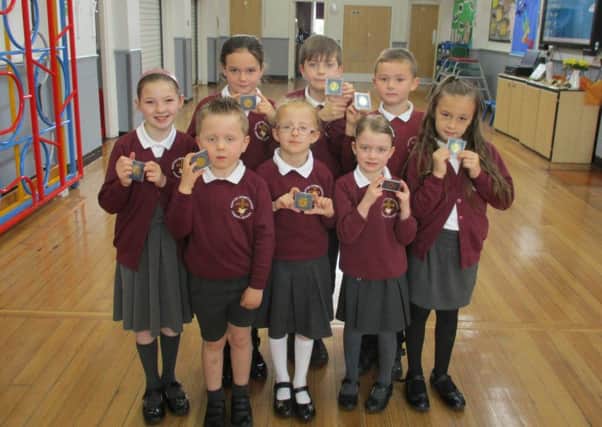 Pupils at Hapton CE/Methodist Primary School with commemorative coins they received from Hapton Parish Council as part of the Queen's 90th birthday celebrations. (S)