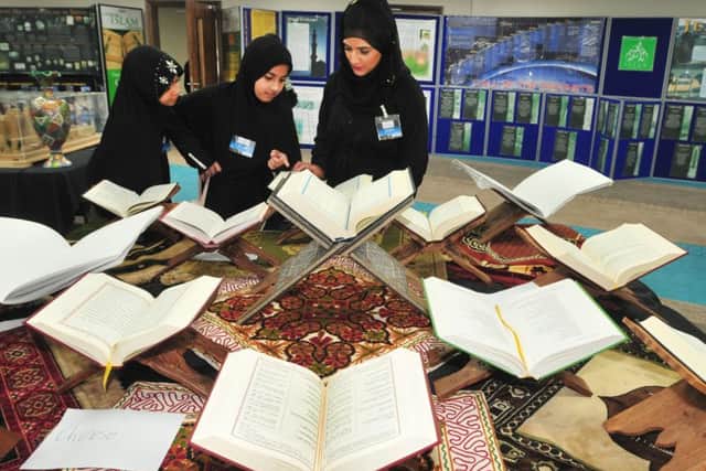 Kulsum Seth looks through the Qur'an in various languages with young visitors to a Ramadhan Awarness Exhibition held in Masjid Salaam Mosque, Preston.
