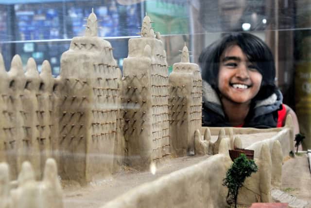Looking at a model of the mud mosque of Djenne on show at a Ramadhan Awarness Exhibition held in Masjid Salaam Mosque, Preston, is Bilal Patel