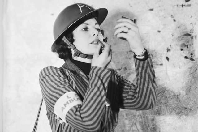 A member of Air Raid Precautions staff applies her lipstick between emergency calls.