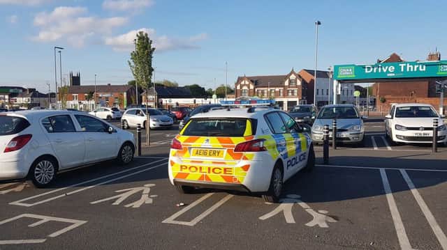 A police car parked across two spaces in the mother and baby space of Asda car park in Chorley.