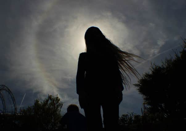 Member of Euxtronomy standing in front of a solar halo (rainbow around the sun)