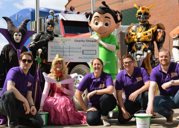 The team behind the Chorley Stars and Cars charity event 2016 with Optimus Prime, Lightning McQueen, Batman, Stormtroopers, Maleficent and Princess Aurora presenting a cheque to Derian House Children's Hospice for Â£8209.37