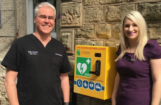 Grant McKeating and Charlie with the new public access defibrillator Grant has purchased for Chorley residents outside his clinic.