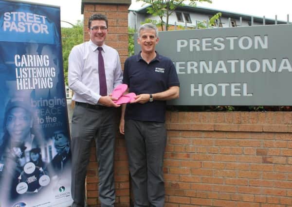 Philip Dunn, general manager at The Legacy Preston International Hotel, donates flip flops to Street Pastor Dave Brown