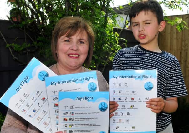 Photo: David Hurst
Rebecca Taylor of Lever House Lane, Leyland, with her son Josh, who suffers from autism, and the information cards she has devised for disabled plane passengers.