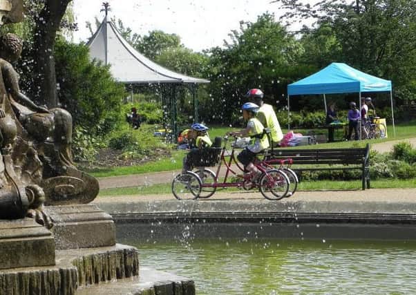 A family cycling around the fountain in Avenham and Miller Parks