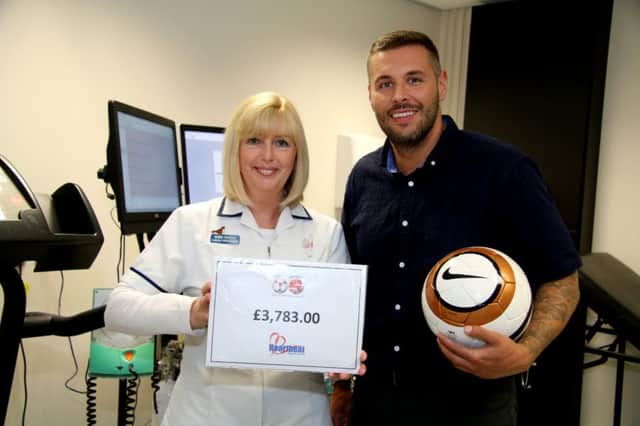 Footballer Craig Ashcroft from Unicorn FC makes the presentation to cardiac physiologist Debbie Crossley, at the Heartbeat HQ in Preston