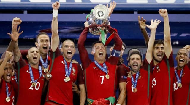 Portugal's Cristiano Ronaldo holds up the Euro 2016 trophy with team-mates