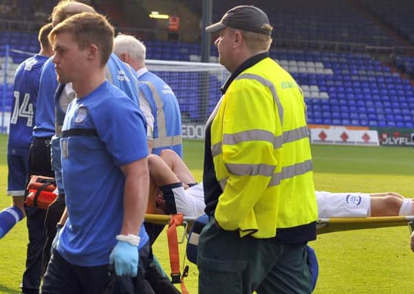 Calum Woods is stretchered off at Boundary Park
