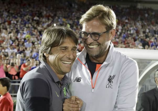 Liverpool coach Jurgen Klopp, right, and Chelsea coach Antonio Conte share a laugh